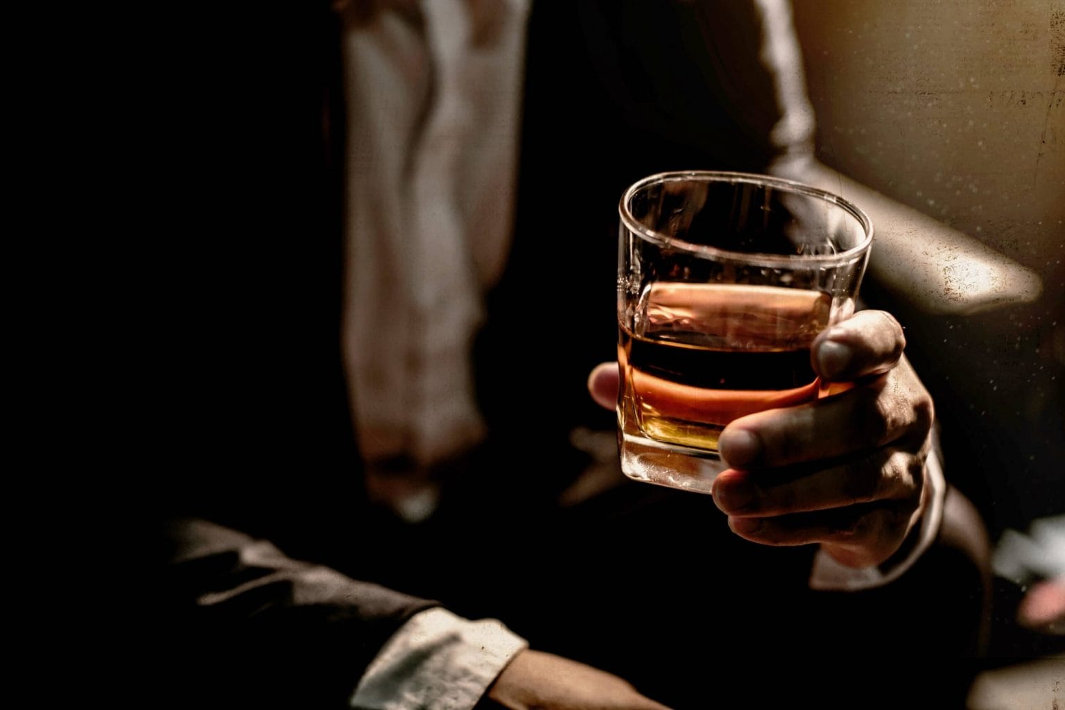Man holding a glass of bourbon